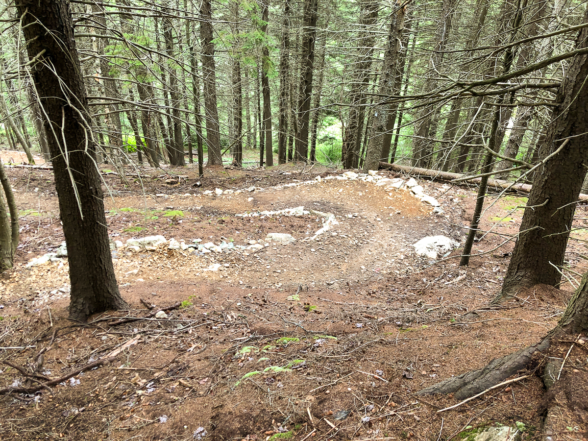 La piste de vélo de montagne serpente en bas d'une colline abrupte sur le sentier Enthusiasts' Path au parc Rockwood à Saint John, au Nouveau-Brunswick